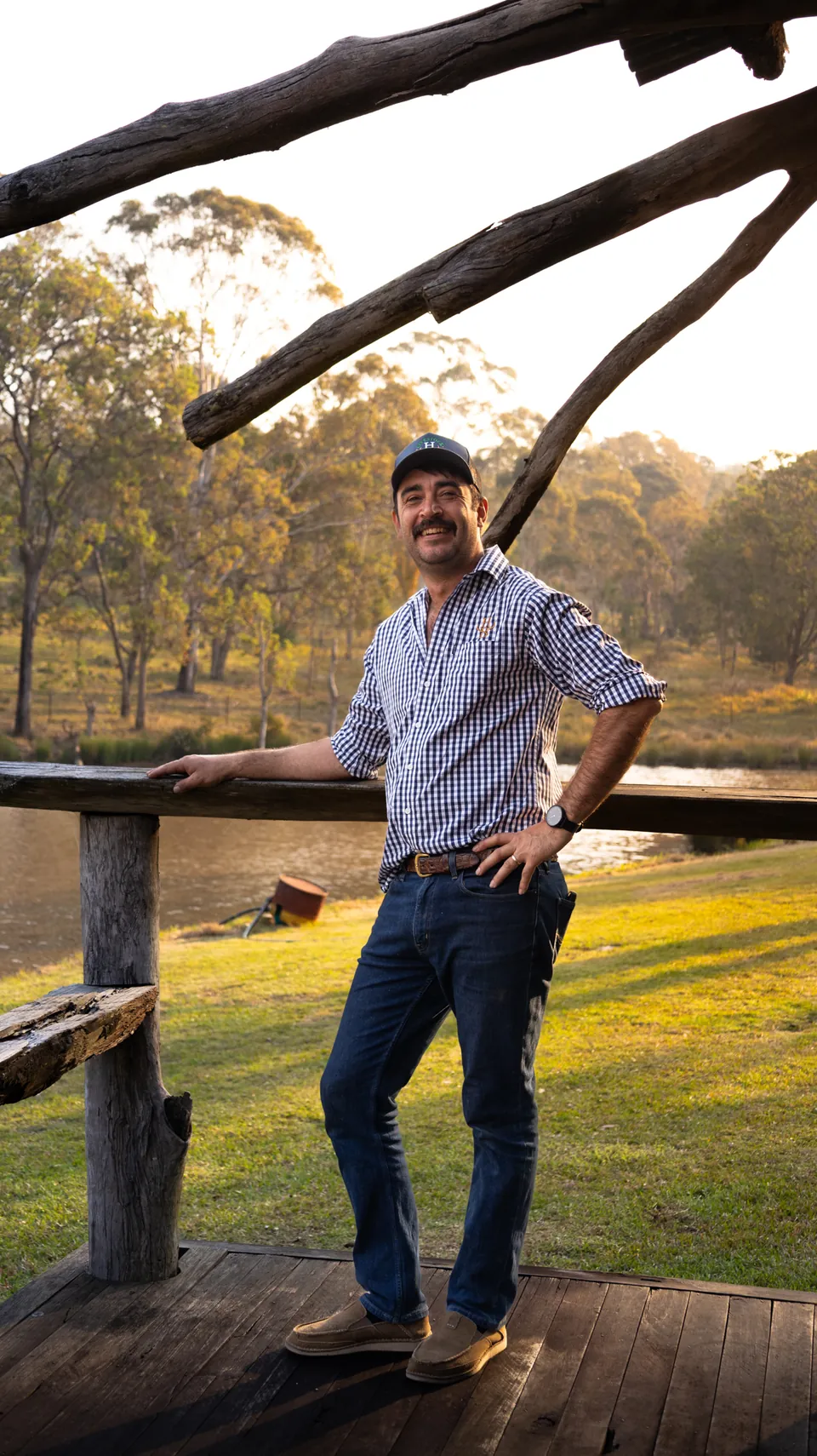 Business owner photographed at a fence line on his property at golden hour