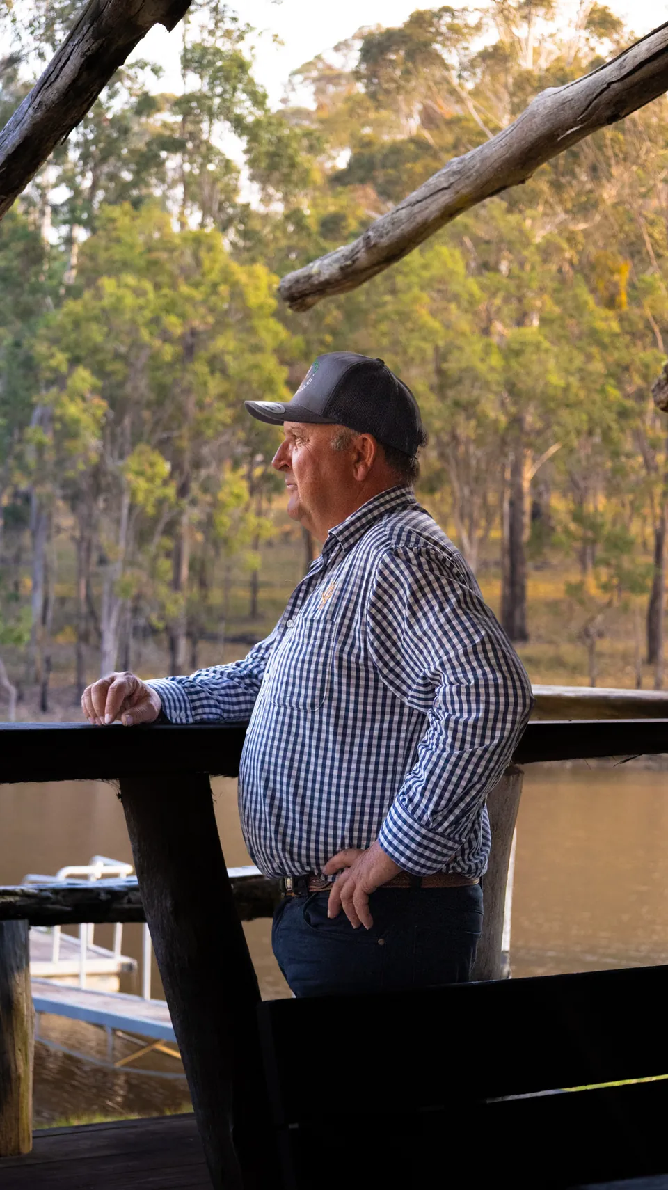 Business owner photographed leaning on a timber rail on his property