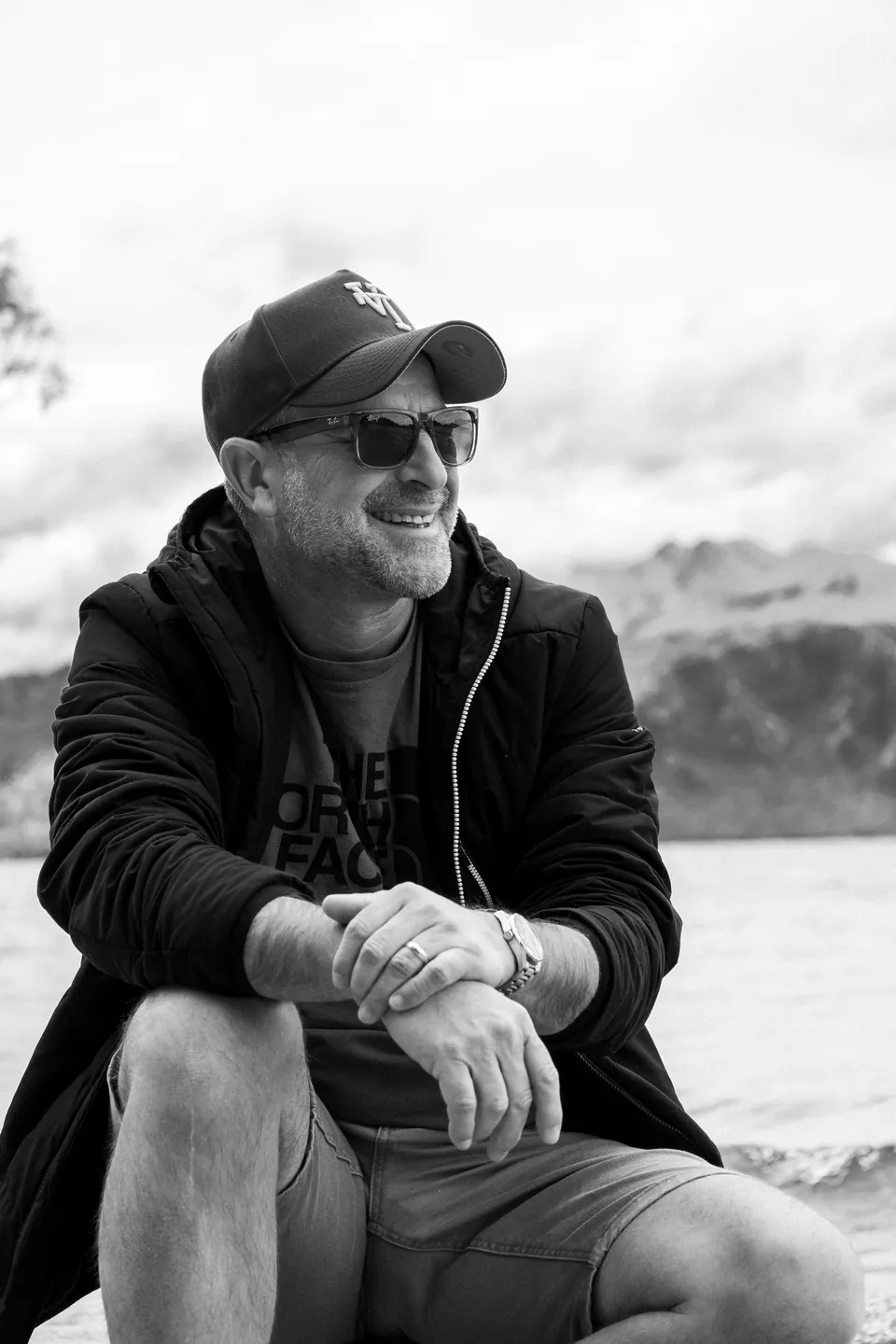Black and white seated portrait of a man outdoors